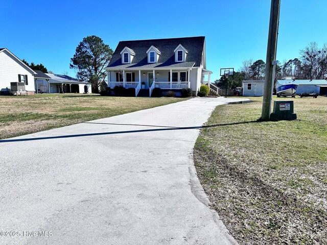 cape cod house with a porch, a front lawn, and a shingled roof