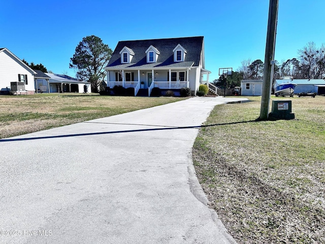 cape cod house featuring covered porch and a front yard