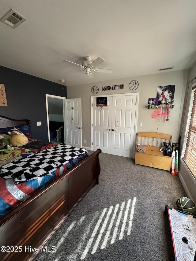 carpeted bedroom featuring a ceiling fan, a closet, visible vents, and baseboards