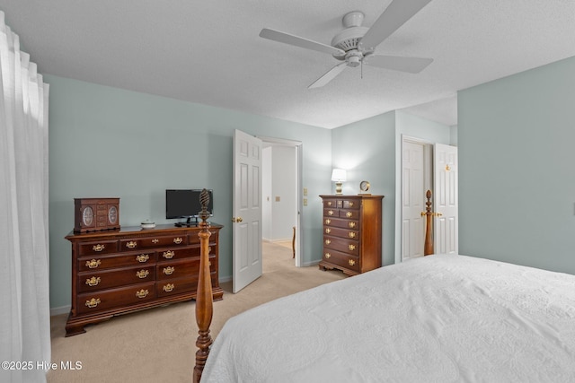 carpeted bedroom featuring a ceiling fan, baseboards, and a textured ceiling