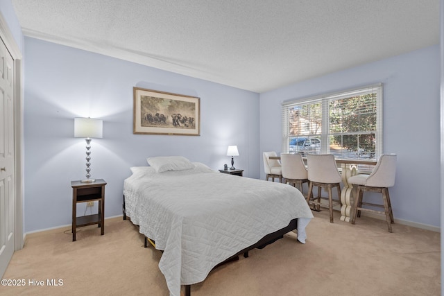 bedroom featuring baseboards, light carpet, a textured ceiling, and a closet