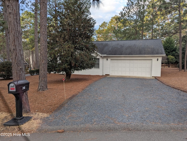 view of front of home featuring a garage, driveway, and roof with shingles