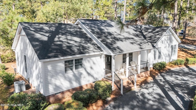 view of front of house with crawl space, cooling unit, a porch, and a shingled roof