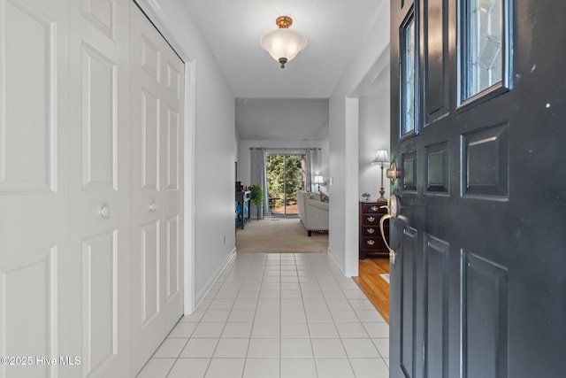 foyer featuring light tile patterned floors and baseboards