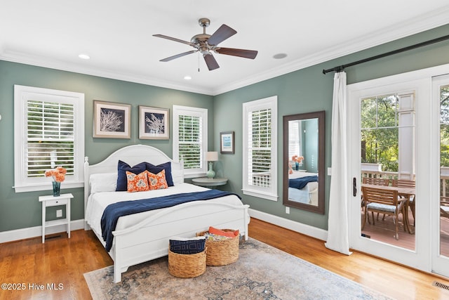 bedroom featuring multiple windows, wood finished floors, ornamental molding, and access to outside