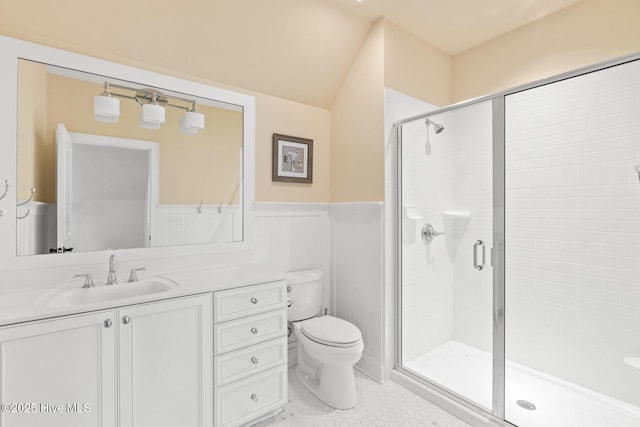 full bathroom featuring vanity, a shower stall, toilet, and a wainscoted wall