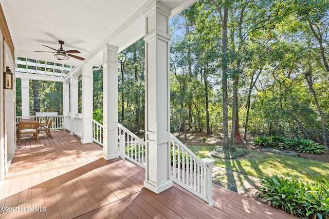 wooden terrace featuring outdoor dining space and a ceiling fan