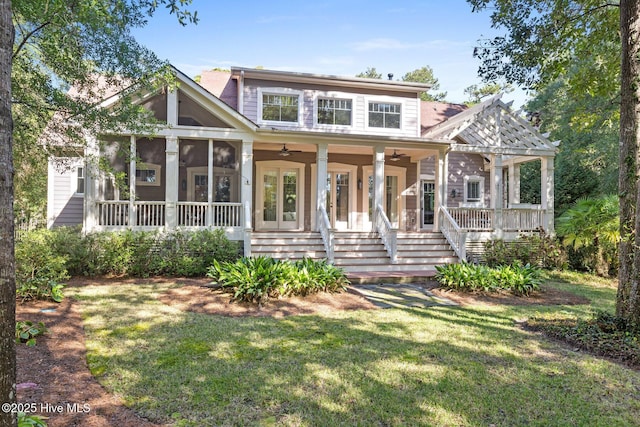 view of front of property with a front lawn, a sunroom, and ceiling fan