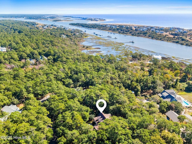 birds eye view of property with a wooded view and a water view