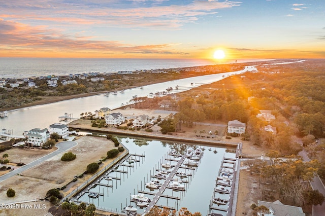 aerial view at dusk featuring a water view