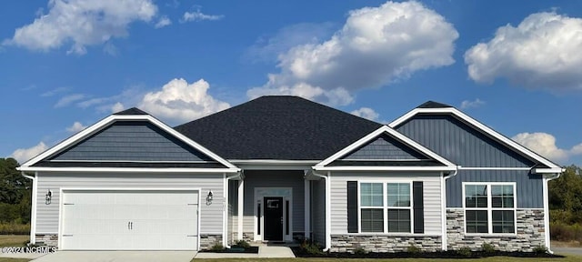 craftsman house featuring stone siding, concrete driveway, board and batten siding, and an attached garage