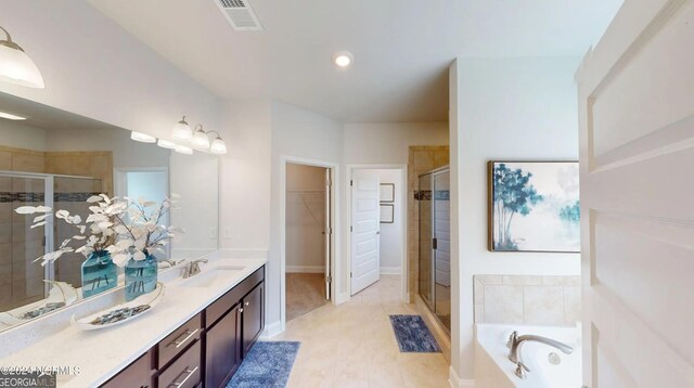 bathroom with a shower stall, a walk in closet, a bath, and vanity