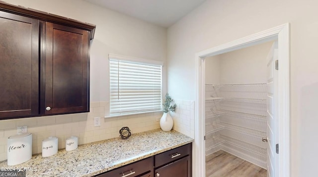 interior space with backsplash and wood finished floors