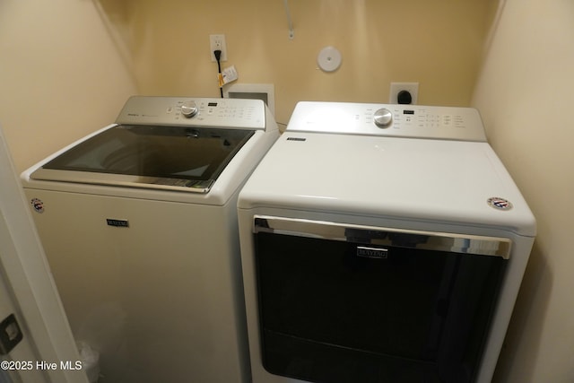 clothes washing area featuring washer and dryer and laundry area