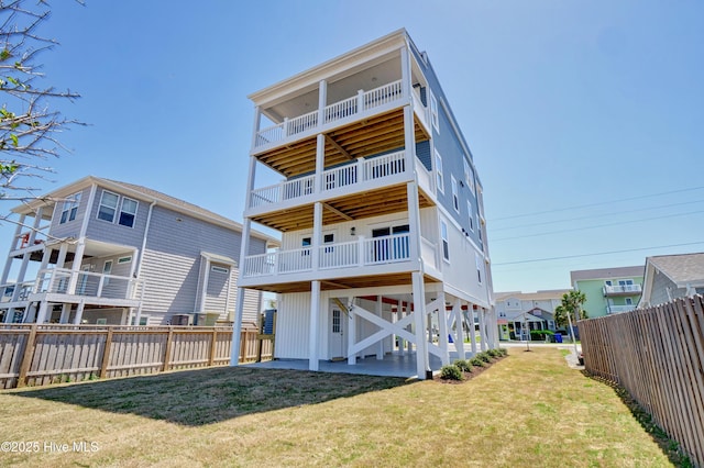 rear view of property featuring a yard, board and batten siding, and fence