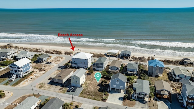 drone / aerial view featuring a residential view, a beach view, and a water view