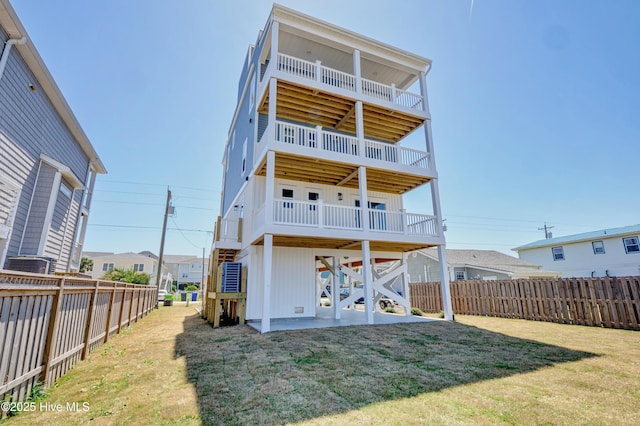 rear view of house featuring a patio area, a lawn, and a fenced backyard