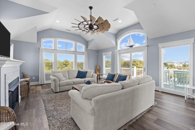 living room with visible vents, ceiling fan, vaulted ceiling, a fireplace, and dark wood-style floors