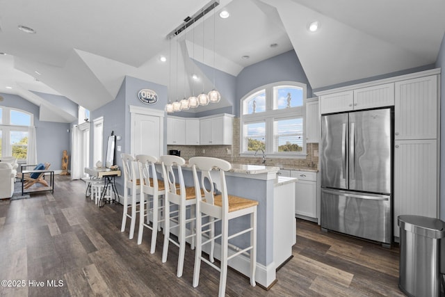 kitchen with plenty of natural light, white cabinets, and freestanding refrigerator