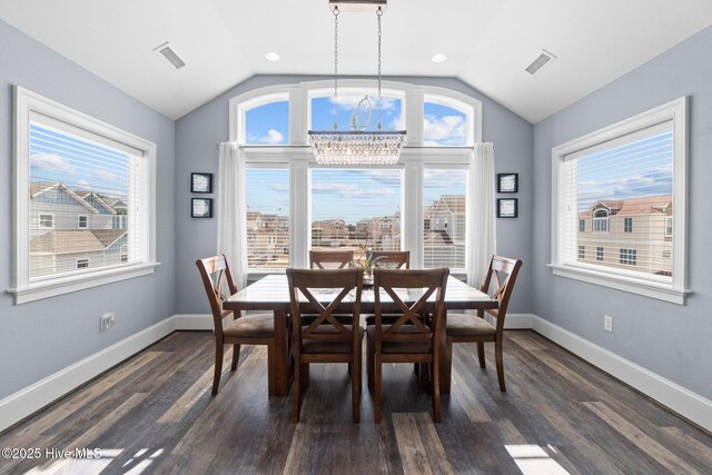 dining room featuring lofted ceiling, a healthy amount of sunlight, dark wood-style flooring, and baseboards