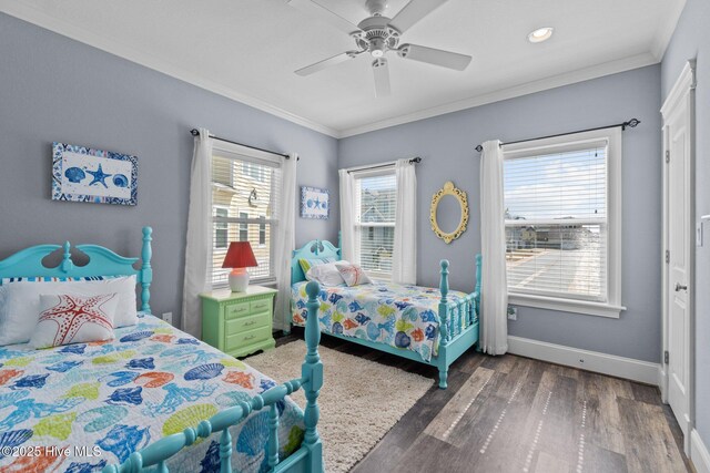 bedroom featuring multiple windows, wood finished floors, baseboards, and ornamental molding