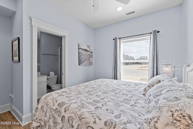 bedroom featuring visible vents, a ceiling fan, wood finished floors, connected bathroom, and baseboards