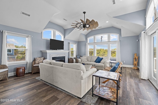 living room featuring a wealth of natural light, a glass covered fireplace, and dark wood-style flooring