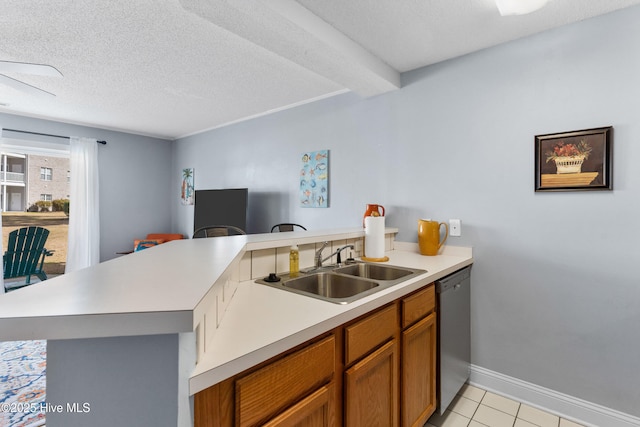 kitchen with brown cabinetry, a peninsula, a sink, light countertops, and stainless steel dishwasher