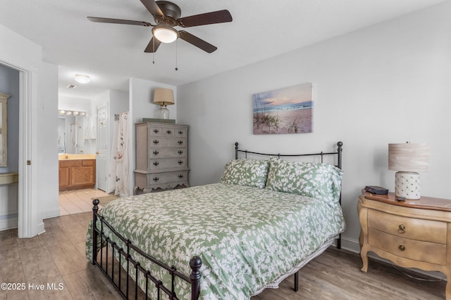 bedroom featuring ceiling fan, baseboards, wood finished floors, and connected bathroom