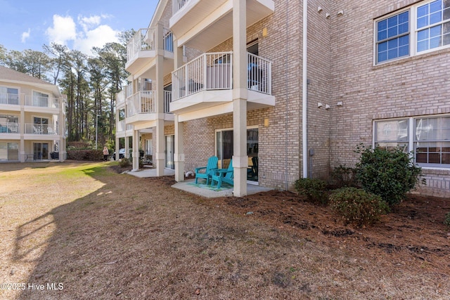 back of property with a patio and brick siding