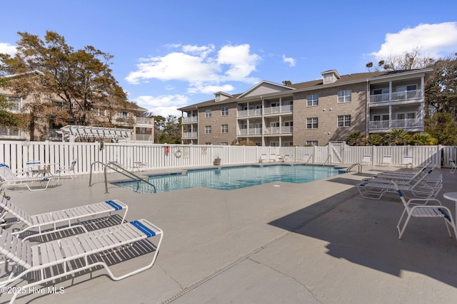 community pool featuring a patio area and fence