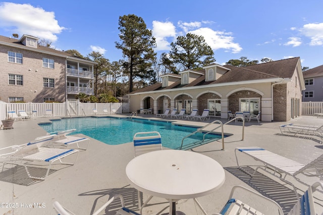 pool featuring fence and a patio