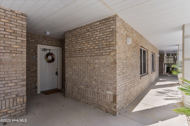 view of exterior entry featuring brick siding