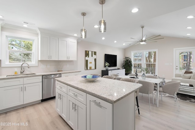 kitchen with visible vents, a sink, dishwasher, open floor plan, and a wealth of natural light