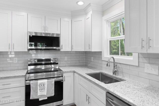 bathroom featuring wood finished floors, a sink, a shower stall, and crown molding