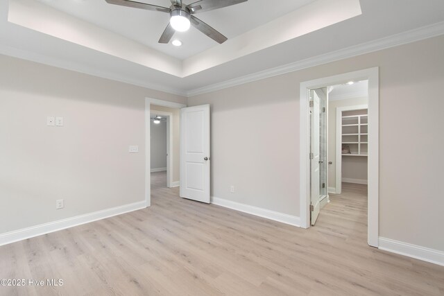 unfurnished room with a ceiling fan, light wood finished floors, baseboards, and ornamental molding