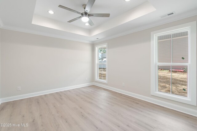 unfurnished room featuring light wood-style floors, ceiling fan, baseboards, and ornamental molding