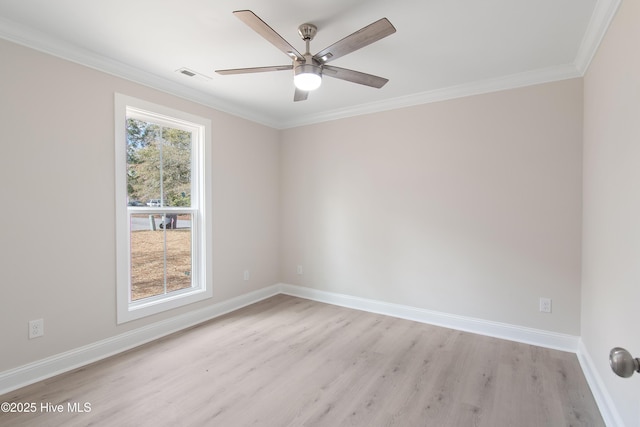 spare room featuring baseboards, visible vents, light wood finished floors, ceiling fan, and crown molding