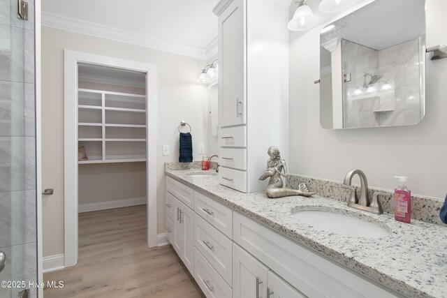 empty room with baseboards, visible vents, light wood-style floors, and crown molding