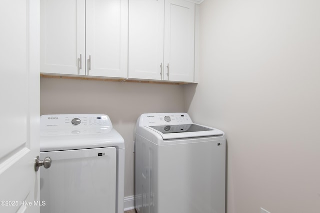 clothes washing area featuring cabinet space and independent washer and dryer