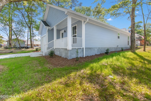 view of side of property with central AC, driveway, covered porch, and a garage
