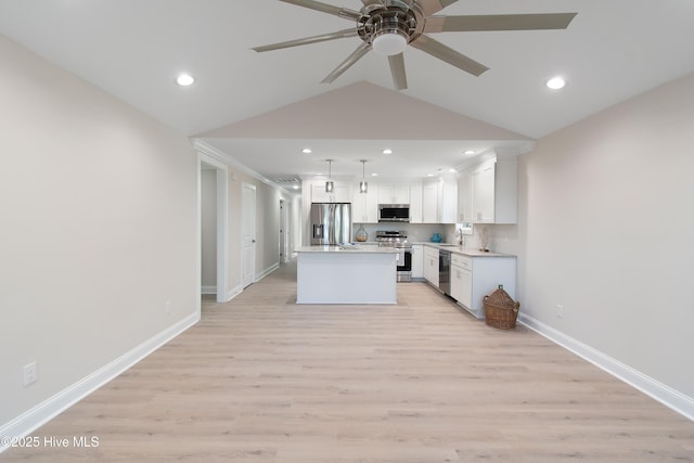 kitchen featuring decorative light fixtures, light wood-style floors, appliances with stainless steel finishes, white cabinets, and light countertops