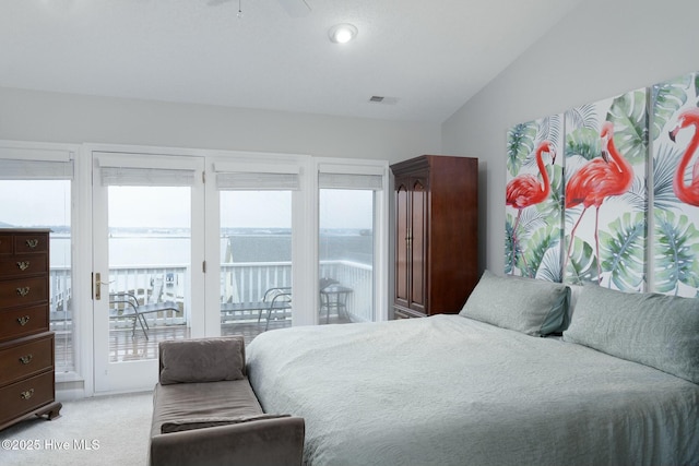 bedroom with lofted ceiling, access to outside, light colored carpet, and visible vents