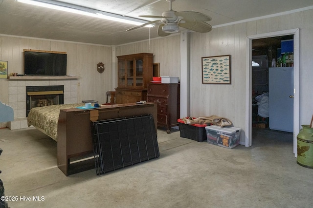 living room with a tiled fireplace, ceiling fan, concrete flooring, and ornamental molding