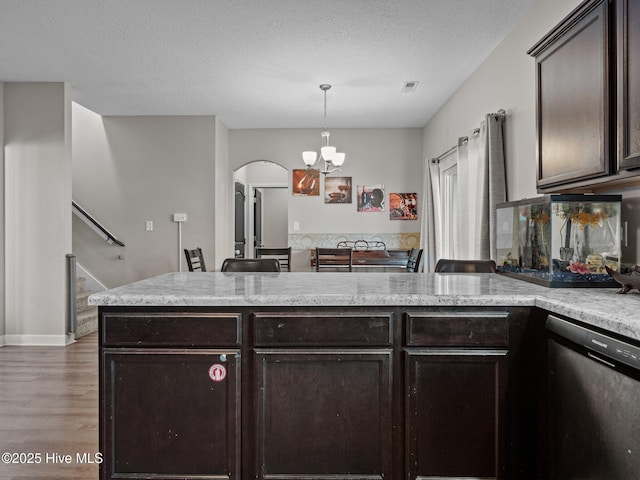 kitchen with visible vents, dark brown cabinets, dishwasher, a peninsula, and wood finished floors