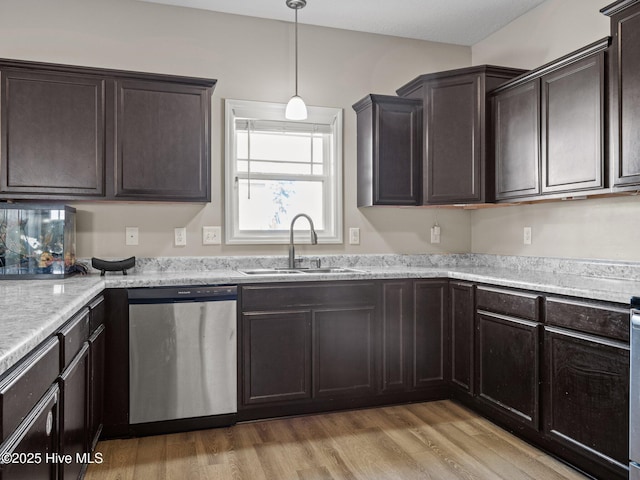 kitchen featuring a sink, hanging light fixtures, dark brown cabinets, light wood-style floors, and dishwasher