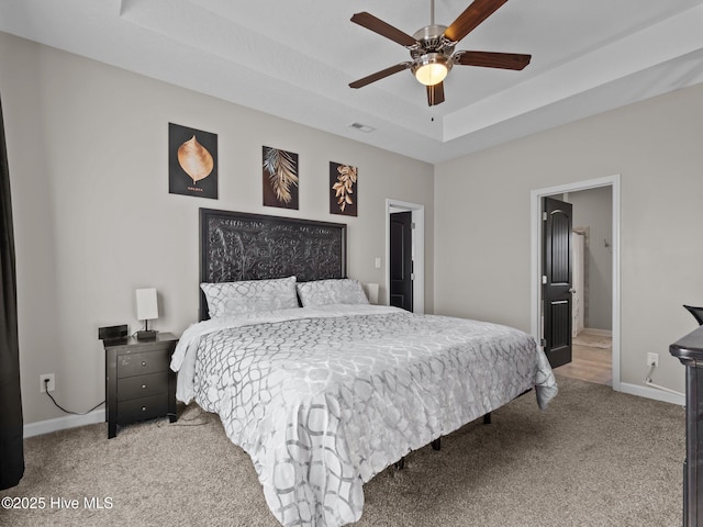 bedroom featuring visible vents, ceiling fan, baseboards, light carpet, and a raised ceiling