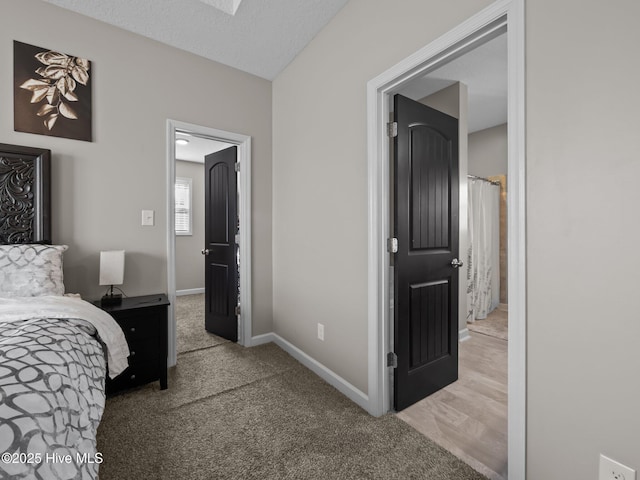 bedroom with baseboards, carpet, and a textured ceiling