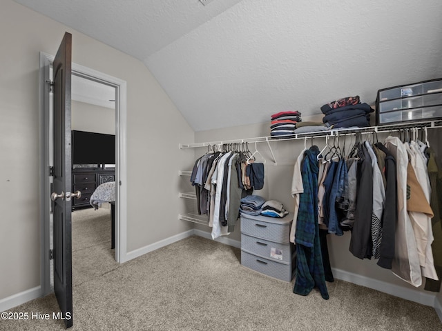 spacious closet featuring carpet and vaulted ceiling