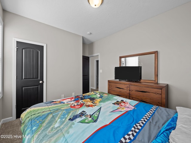 bedroom featuring carpet flooring, baseboards, and a textured ceiling